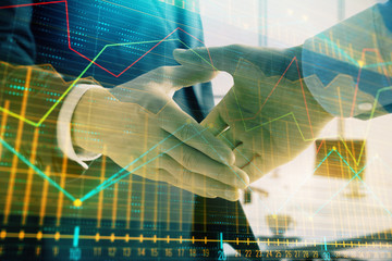 Multi exposure of financial graph on office background with two businessmen handshake. Concept of success in business