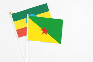 French Guiana and Ethiopia stick flags on white background. High quality fabric, miniature national flag. Peaceful global concept.White floor for copy space.
