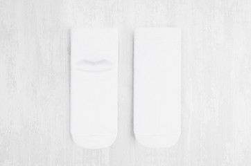 Pair blank white medium socks flat lay on white wood board, front view, backside - mock up for...