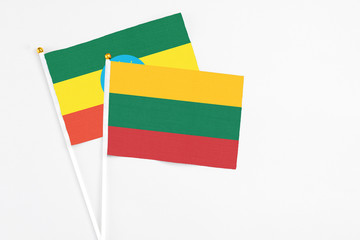 Lithuania and Ethiopia stick flags on white background. High quality fabric, miniature national flag. Peaceful global concept.White floor for copy space.
