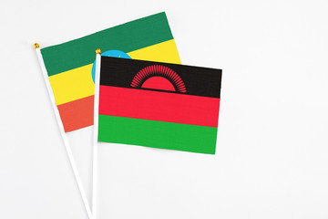Malawi and Ethiopia stick flags on white background. High quality fabric, miniature national flag. Peaceful global concept.White floor for copy space.
