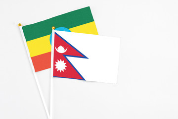 Nepal and Ethiopia stick flags on white background. High quality fabric, miniature national flag. Peaceful global concept.White floor for copy space.