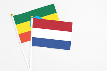 Netherlands and Ethiopia stick flags on white background. High quality fabric, miniature national flag. Peaceful global concept.White floor for copy space.