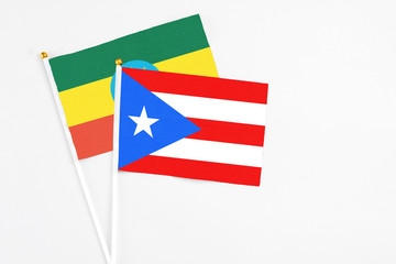 Puerto Rico and Ethiopia stick flags on white background. High quality fabric, miniature national flag. Peaceful global concept.White floor for copy space.