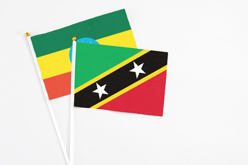 Saint Kitts And Nevis and Ethiopia stick flags on white background. High quality fabric, miniature national flag. Peaceful global concept.White floor for copy space.