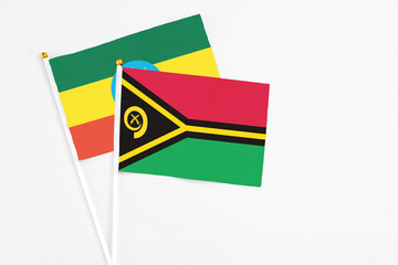 Vanuatu and Ethiopia stick flags on white background. High quality fabric, miniature national flag. Peaceful global concept.White floor for copy space.