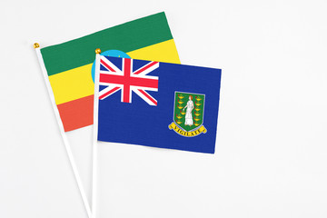 British Virgin Islands and Ethiopia stick flags on white background. High quality fabric, miniature national flag. Peaceful global concept.White floor for copy space.