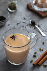Indian masala tea with spices on a gray background