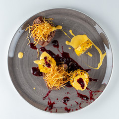 Fillet mignon with grilled corn, caramelized onions and cranberry sauce isolated on white background