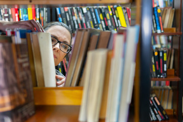 woman in the library in front of bookshelves. Concept of education