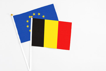 Belgium and European Union stick flags on white background. High quality fabric, miniature national flag. Peaceful global concept.White floor for copy space.