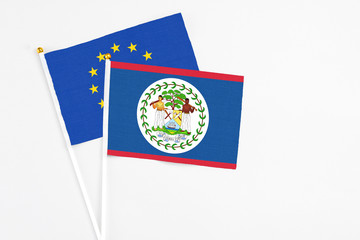 Belize and European Union stick flags on white background. High quality fabric, miniature national flag. Peaceful global concept.White floor for copy space.