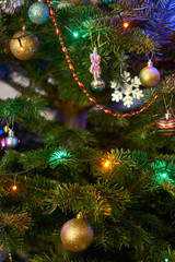 New Year's composition, Christmas decorations. Christmas toys hanging on a fir-tree against the background of a luminous Christmas garland