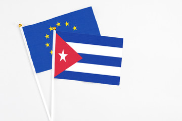 Cuba and European Union stick flags on white background. High quality fabric, miniature national flag. Peaceful global concept.White floor for copy space.