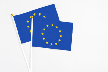 European Union and European Union stick flags on white background. High quality fabric, miniature national flag. Peaceful global concept.White floor for copy space.