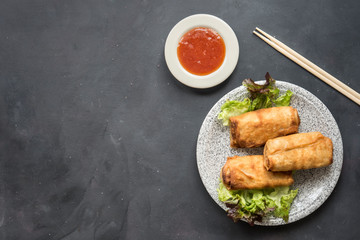 fried vegetable spring rolls with fresh ingredients served and sour sauce in an oriental restaurant