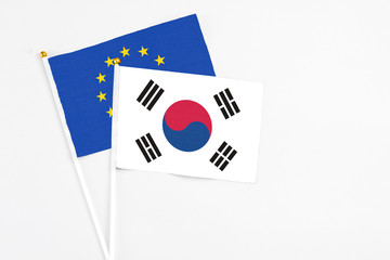 South Korea and European Union stick flags on white background. High quality fabric, miniature national flag. Peaceful global concept.White floor for copy space.