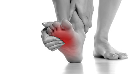 woman massaging her painful foot on white background