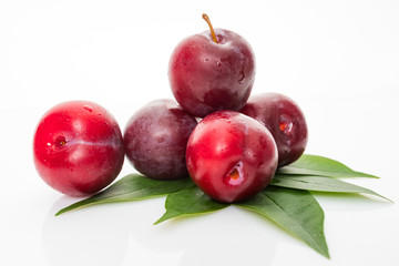 plums with plum leaves on a white background