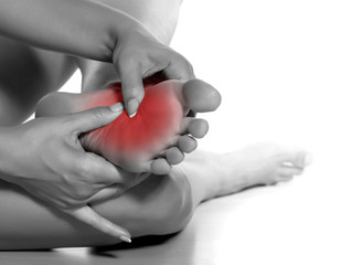 woman massaging her painful foot on white background