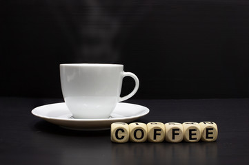 Coffee cup espresso hot white on wooden board with letters.