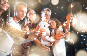 Group of cheerful young people have party and celebrating new year indoors
