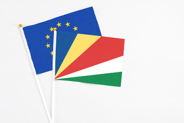 Seychelles and European Union stick flags on white background. High quality fabric, miniature national flag. Peaceful global concept.White floor for copy space.