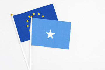 Somalia and European Union stick flags on white background. High quality fabric, miniature national flag. Peaceful global concept.White floor for copy space.