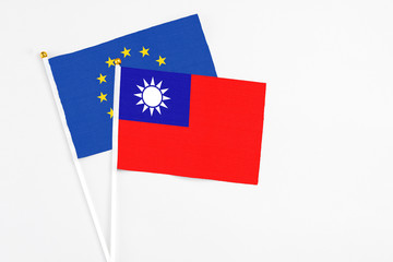 Taiwan and European Union stick flags on white background. High quality fabric, miniature national flag. Peaceful global concept.White floor for copy space.