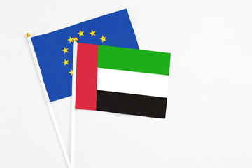 United Arab Emirates and European Union stick flags on white background. High quality fabric, miniature national flag. Peaceful global concept.White floor for copy space.