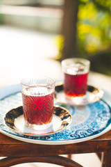 Two crystal glasses of black tea with saucers in garden, Novruz or Ramadan celebration, copy space