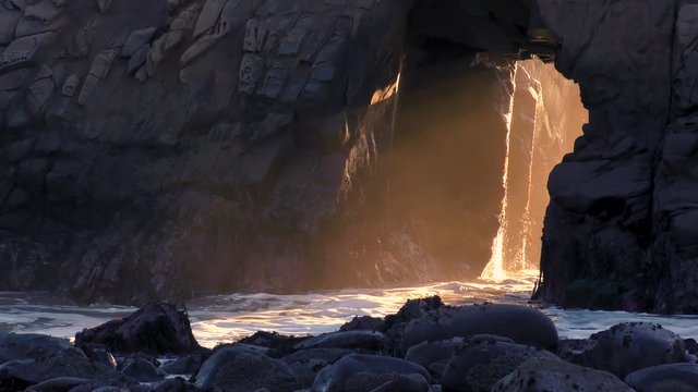 Mysterious keyhole rock dripping off the ocean water at sunset 