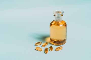 Omega 3 gel capsules. Fish oil pills. Healthy omega-3 and bottle of oil on blue table.