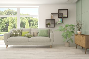 Fototapeta premium Stylish room in white color with sofa and summer landscape in window. Scandinavian interior design. 3D illustration
