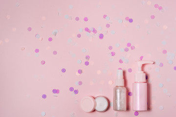 Cosmetic bottle containers on pink color background.