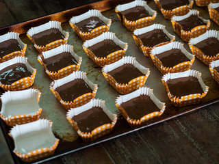 Processing homemade chocolate cupcakes on tray.