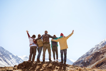 Happy friends hugging together mountains