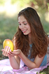 Jolie jeune fille mangeant une mangue