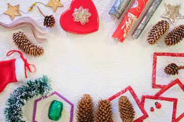 Winter or Christmas composition. Frame made of gift box, wrapping paper, spruce cones, stars, on white snowy background. Christmas, winter, new year concept. Flat lay, top view, copy space.