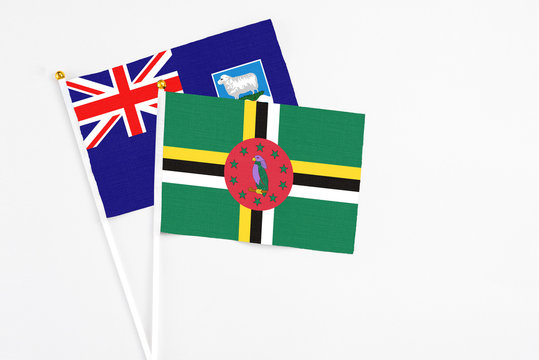 Dominica and Falkland Islands stick flags on white background. High quality fabric, miniature national flag. Peaceful global concept.White floor for copy space.