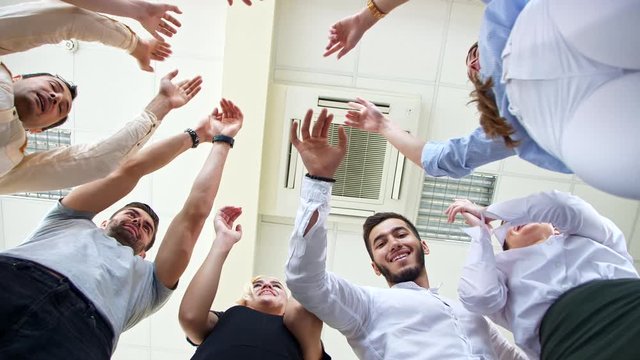 Company of young employees Low Angle View Stacking Hands Together in office