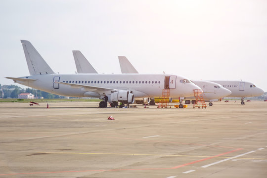 Three different narrow-body aircraft parked at the airport are lined up.