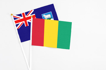 Guinea and Falkland Islands stick flags on white background. High quality fabric, miniature national flag. Peaceful global concept.White floor for copy space.