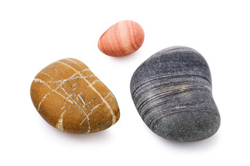 Smooth sea pebbles isolated on a white background. Colored stones close-up. Stacked photo