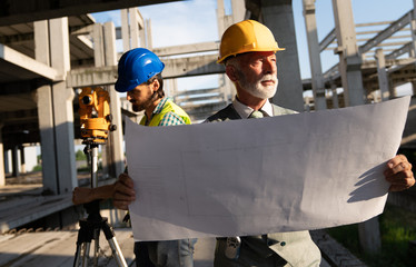 Architect and construction engineer or surveyor discussion plans and blueprints