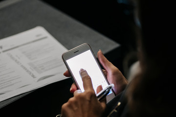 Detail of a woman's hands using a mobile phone or tablet at a congress