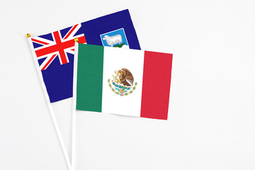Fototapeta premium Mexico and Falkland Islands stick flags on white background. High quality fabric, miniature national flag. Peaceful global concept.White floor for copy space.