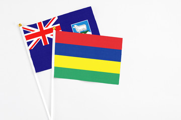 Mauritius and Falkland Islands stick flags on white background. High quality fabric, miniature national flag. Peaceful global concept.White floor for copy space.