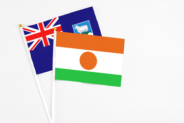 Niger and Falkland Islands stick flags on white background. High quality fabric, miniature national flag. Peaceful global concept.White floor for copy space.