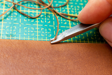 beveling cutting edge on the brown leather stripe for belt with special tool